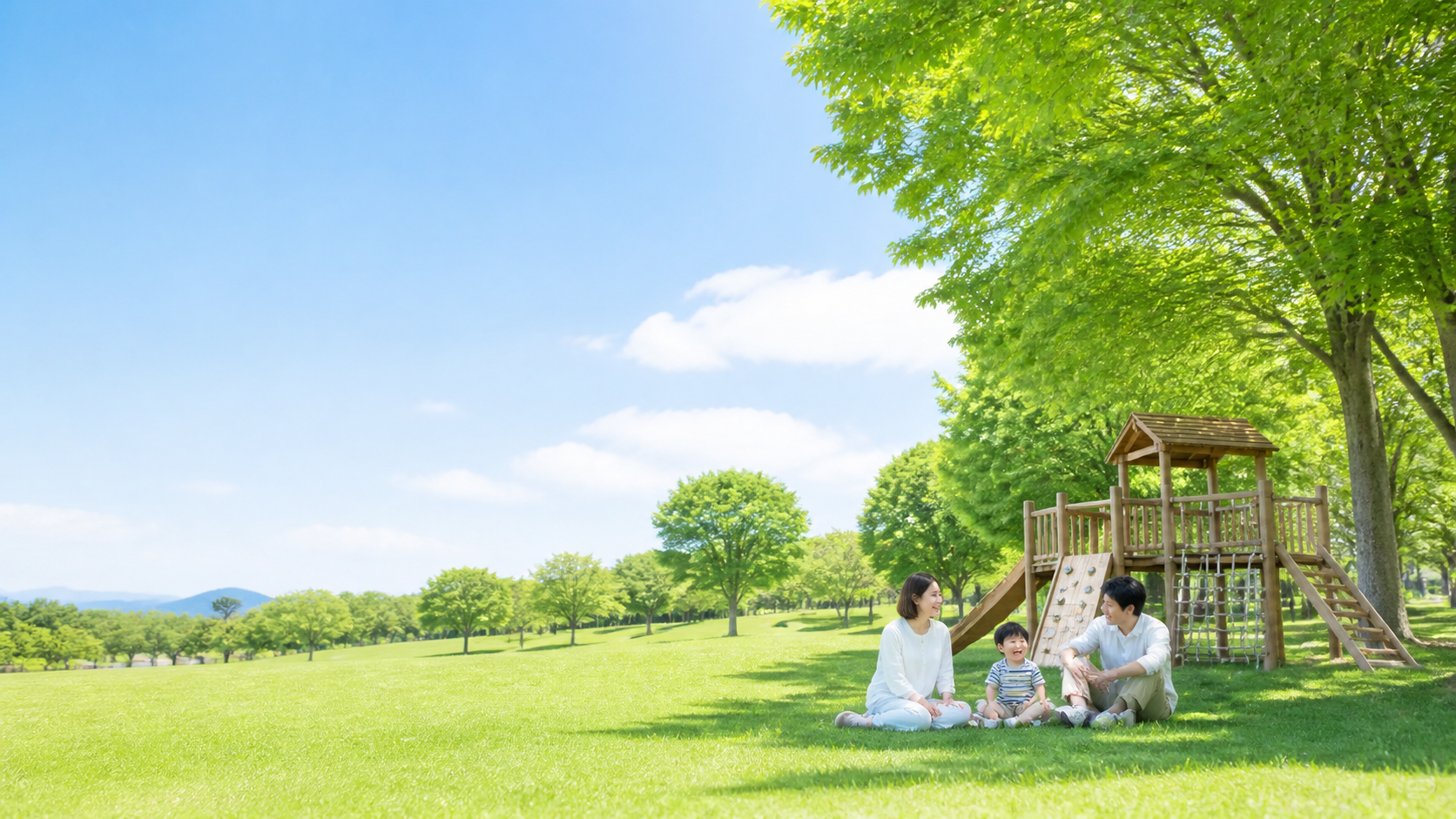 芝生広場と遊具で家族が過ごす公園のイメージ